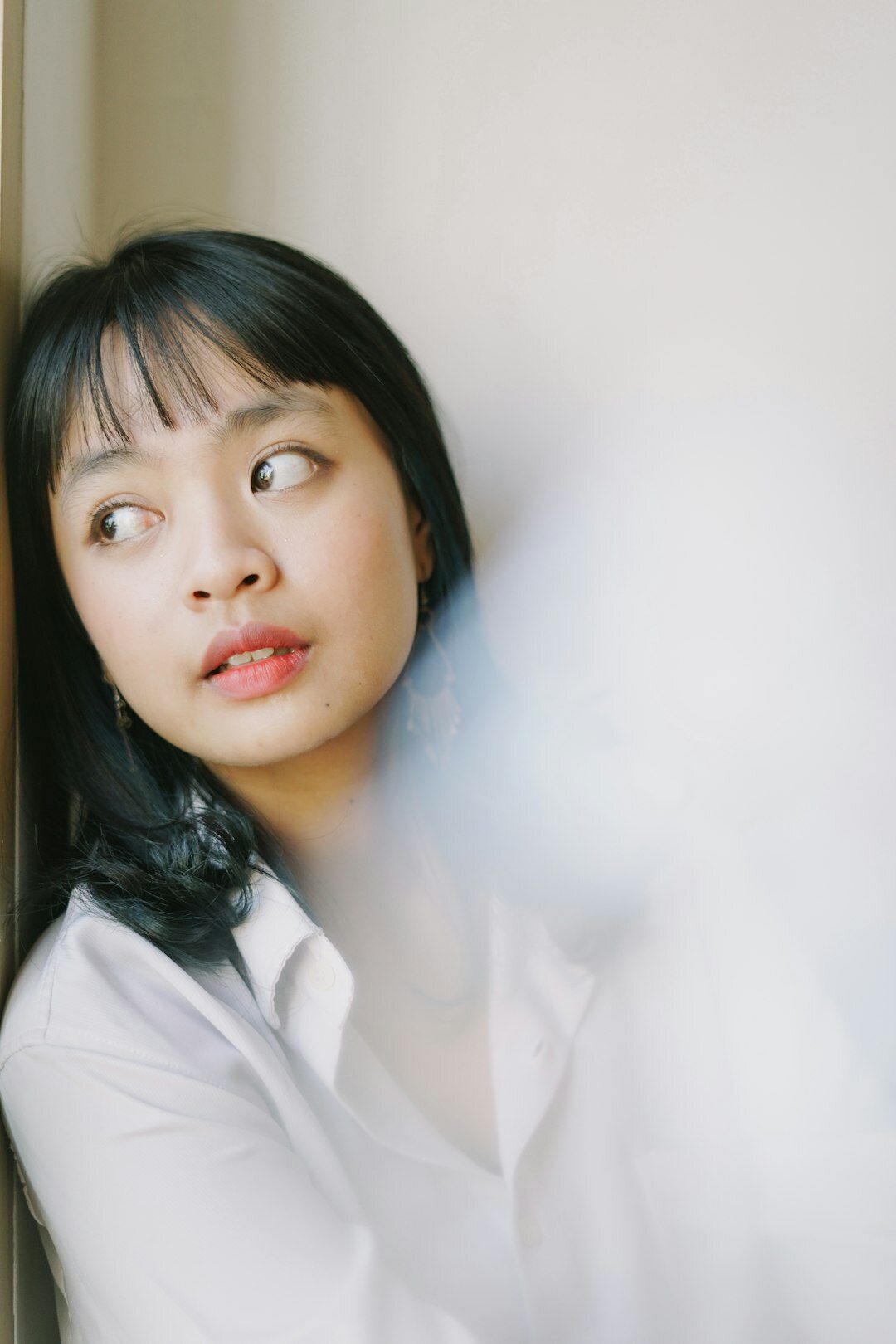 Studio portrait of a Chinese Singaporean woman in her thirties, smiling, wearing business attire