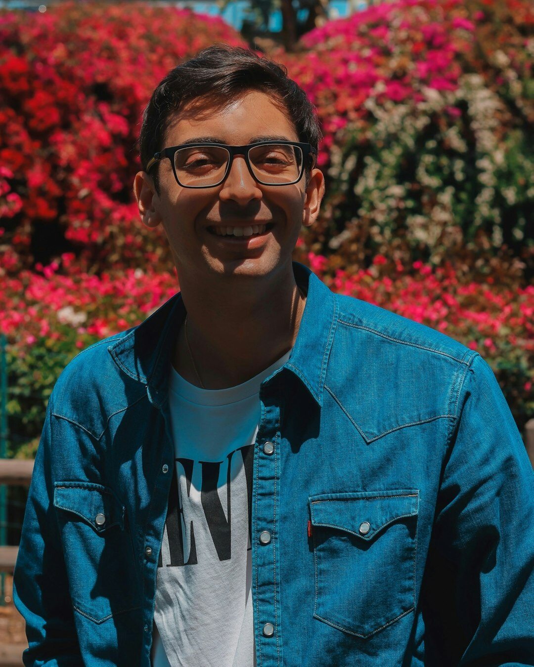 Studio portrait of an Indian Singaporean man in his thirties, wearing a shirt, smiling